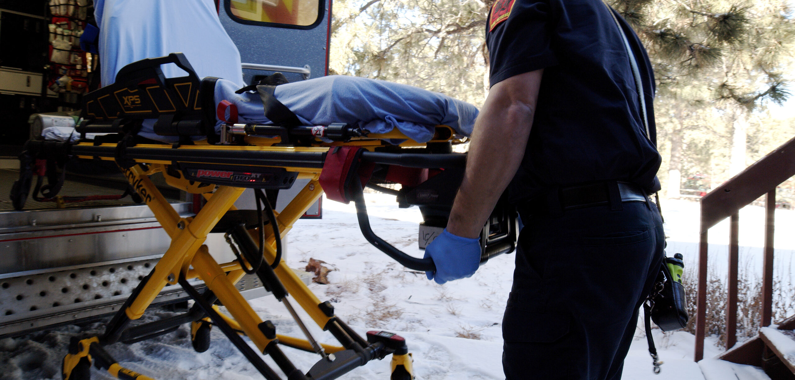 Picture of firefighter unloading gurney out of an ambulance